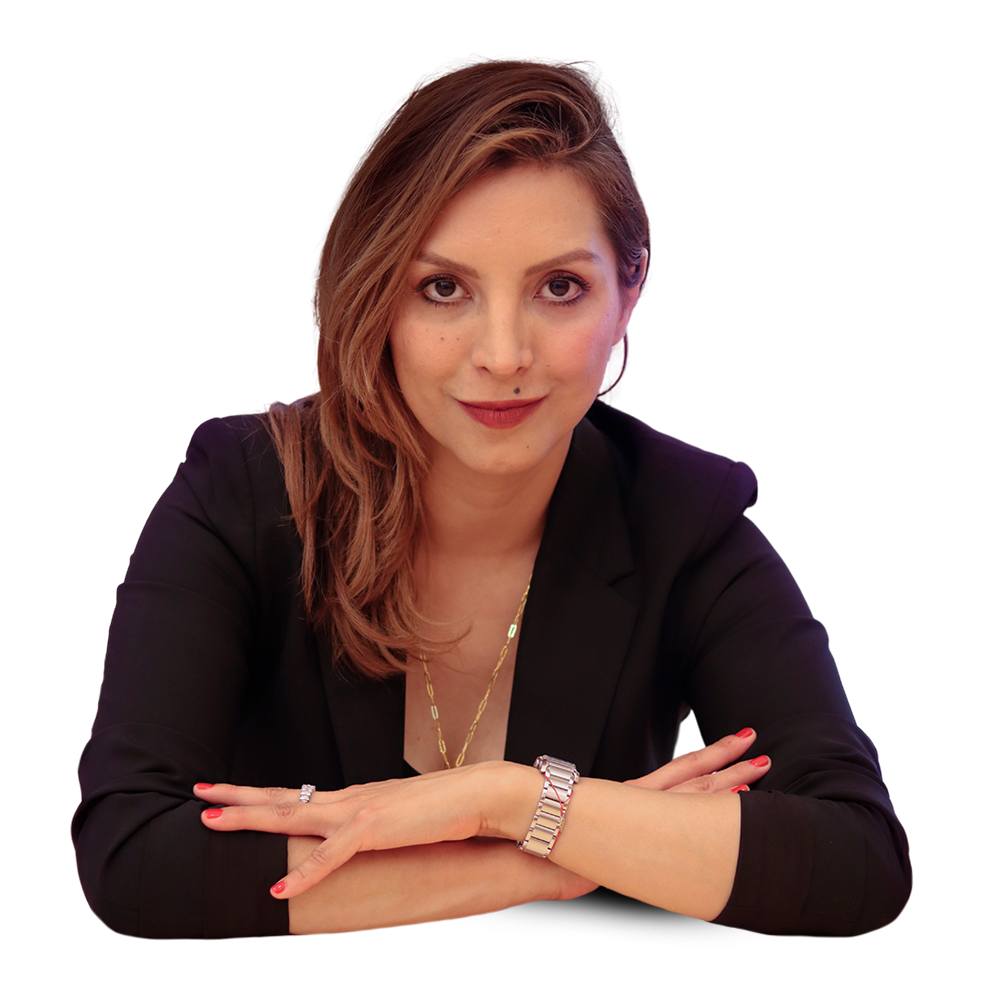 Luisa Bustamante, con los brazos cruzados sobre una mesa, mirando a la cámara